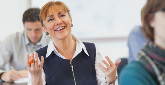 Middle aged practitioner in CPE class with animated expression as though she is engaging with the seminar facilitator