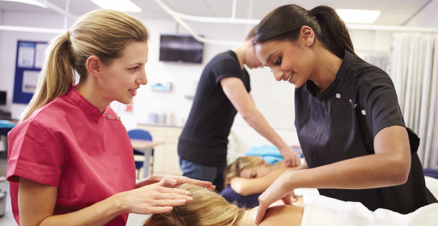 Students being instructed in classroom on massage technique