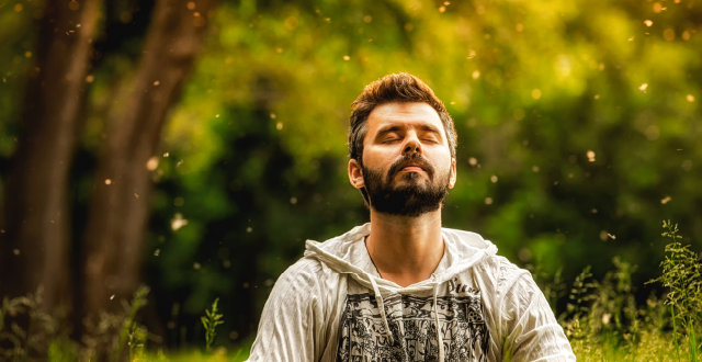 Man meditating in the forest, relaxed and with peace of mind