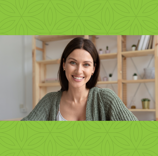 Women wearing sage green cardigan smiling at viewer