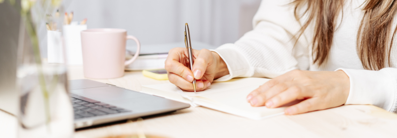 A close-up of hands writing, symbolizing content creation and blogging efforts.