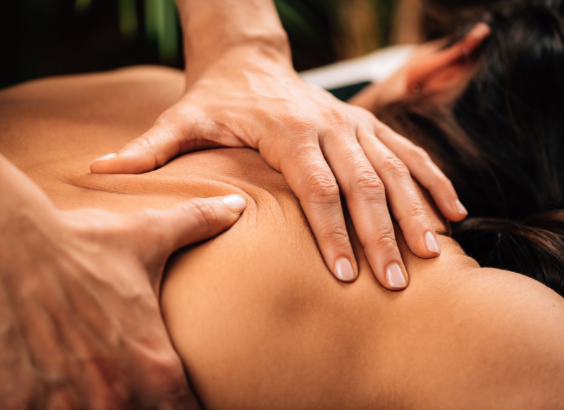 A woman receiving a relaxing back massage in a serene spa setting, with soft lighting and calming decor.